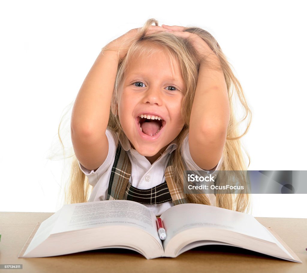 sweet little schoolgirl pulling her blonde hair in happy stress sweet little schoolgirl pulling her blonde hair playing in stress getting crazy while doing homework in children education concept isolated on white background Adversity Stock Photo