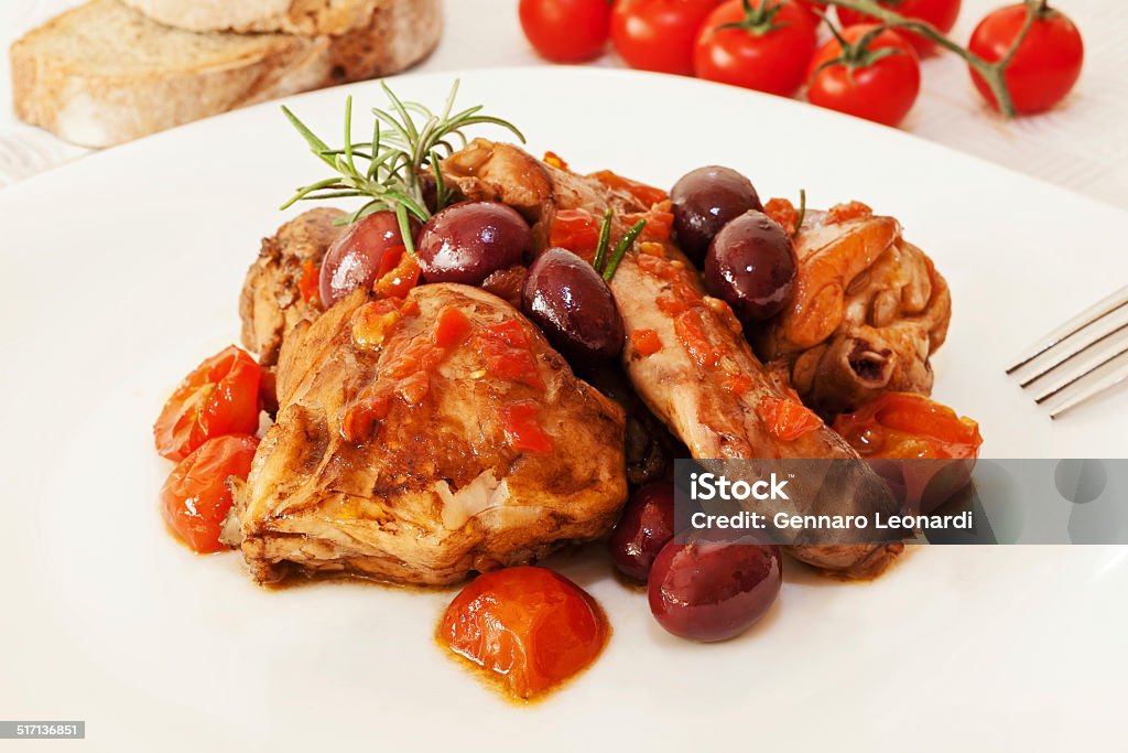 Rabbit cooked tomato and olives. Rabbit into pieces, cooked in a pan with tomatoes, olives, rosemary, fennel seeds, olive oil and white wine. Baked Stock Photo