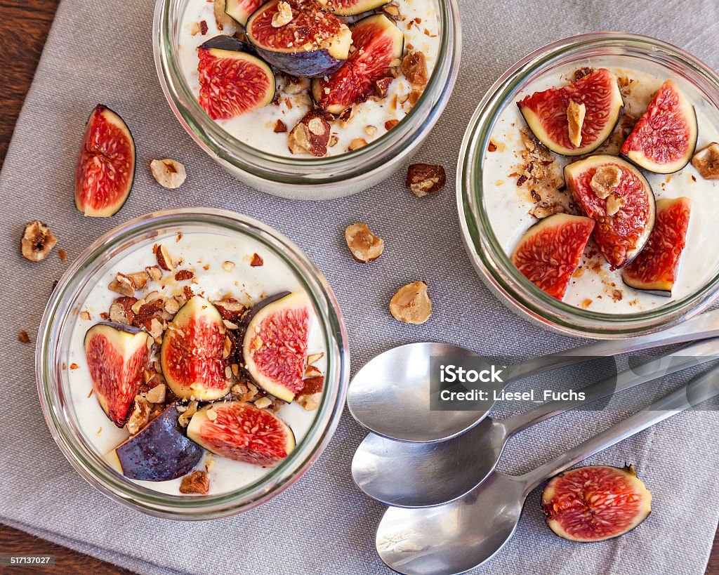 yogurt topped with fresh figs and roasted hazelnuts Yogurt deliciously served in jars topped with fresh figs and roasted hazelnuts Breakfast Stock Photo