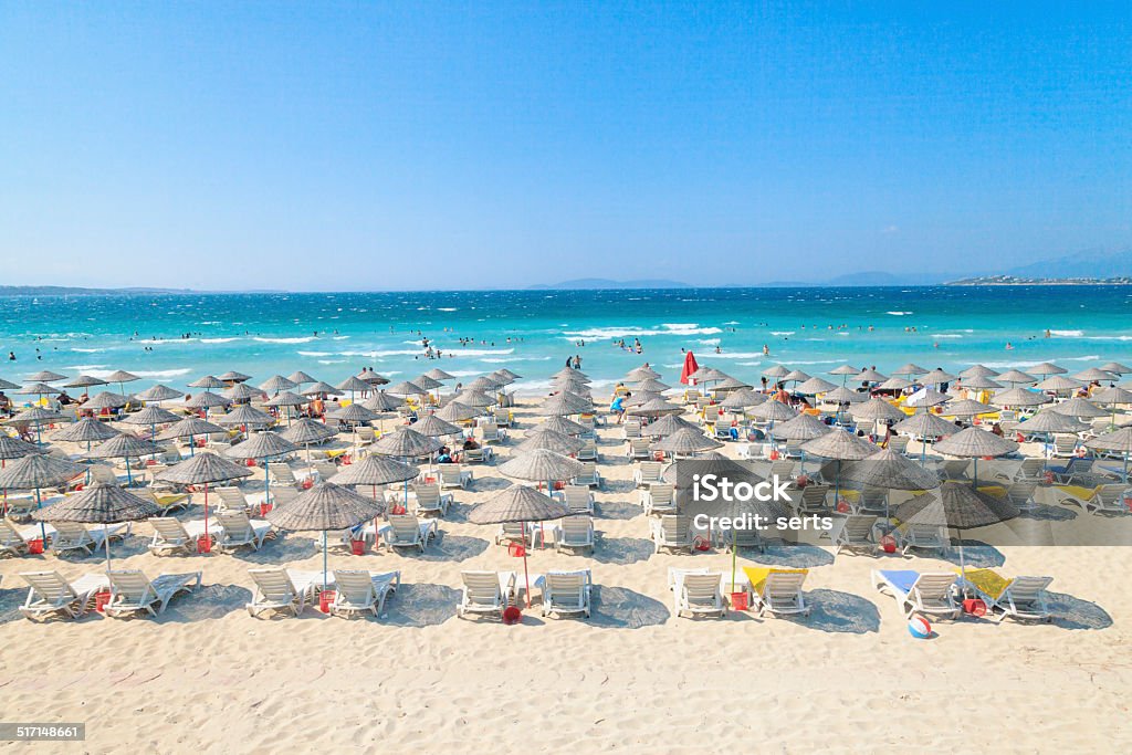 Summer Vacation Beach Empty idyllic tropical white sand beach with lounge chairs and umbrellas. Beach Stock Photo