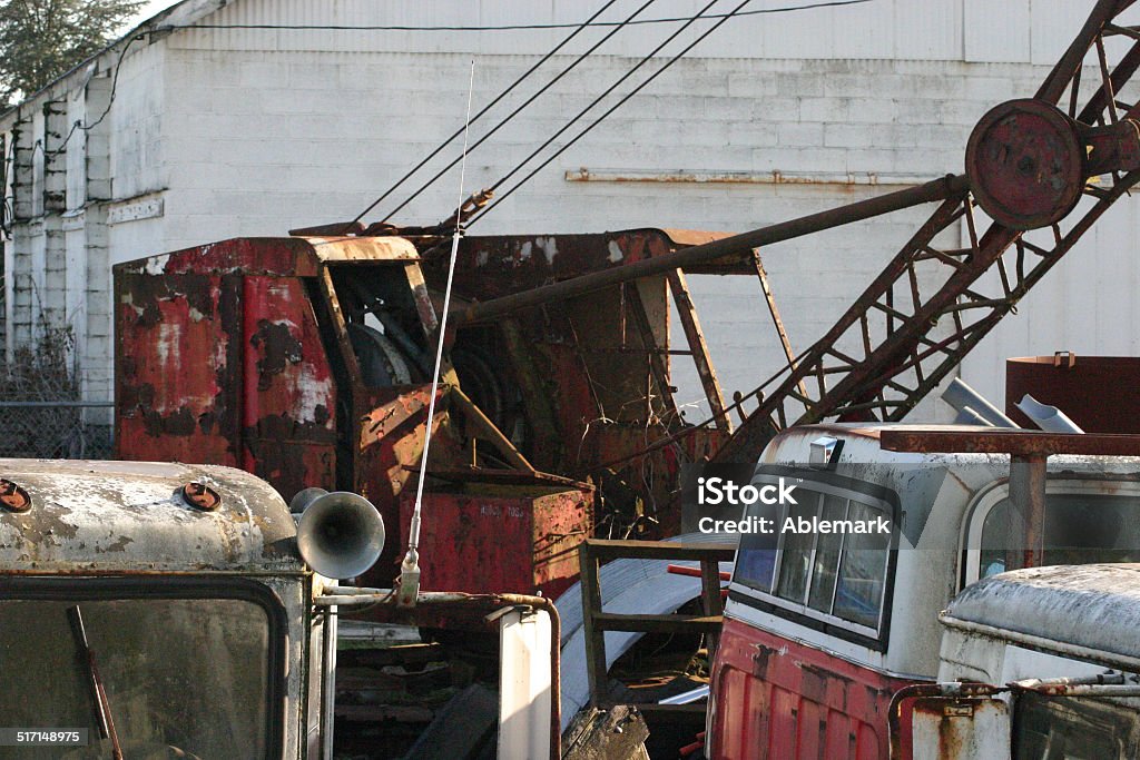 rusty old crane Rusty old crane and trucks sit in junk yard. Horizontal Stock Photo