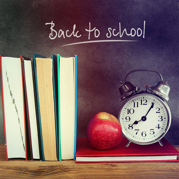 istock Still life with school books and apple against blackboard. 517150421