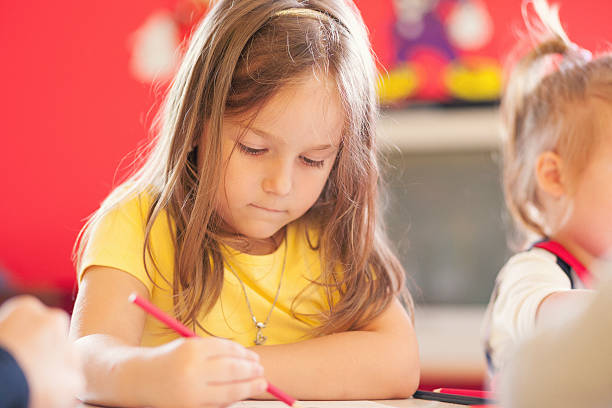 istock Cute little girl drawing in the classroom 517150836