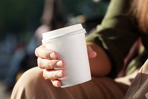 istock Young woman drinking coffee from disposable cup 517151117