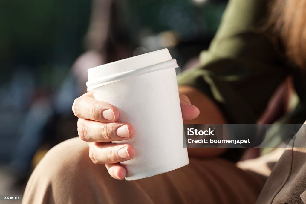 Young woman drinking coffee from disposable cup Paper Coffee Cup Stock Photo