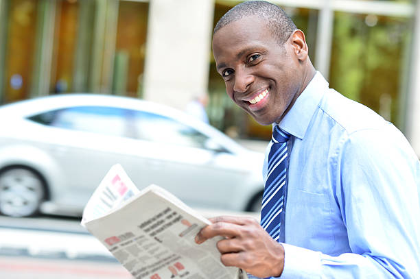 istock Handsome businessman reading a newspaper 517151197
