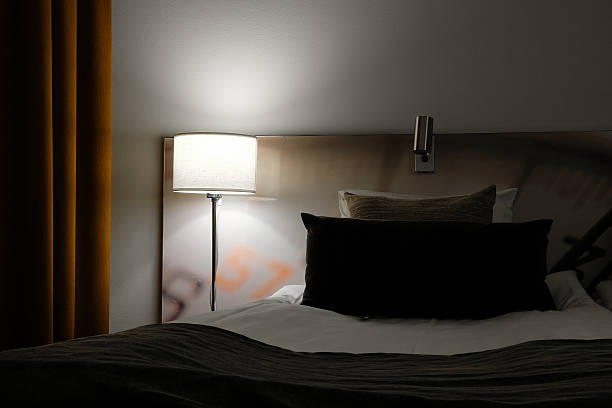 Empty bed in a hotel room stock photo