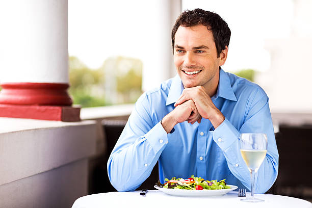 istock Man Sitting With Salad And Wineglass At Restaurant Table 517151343