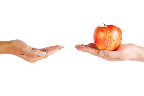 istock Mans hand is giving an apple 517151781