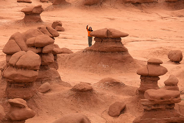 kobieta analizuje wielki kamień grzyby utah to goblin park stanowy dolina - goblin valley state park zdjęcia i obrazy z banku zdjęć