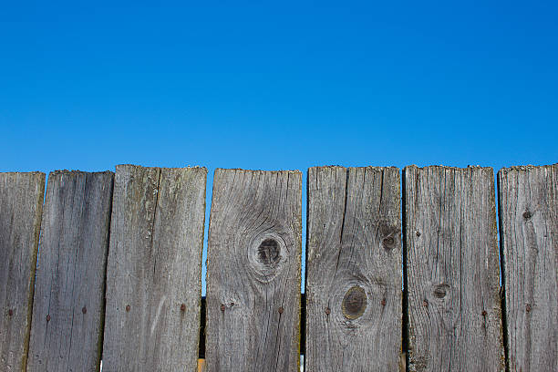 Wooden fence against a blue autumn sky.