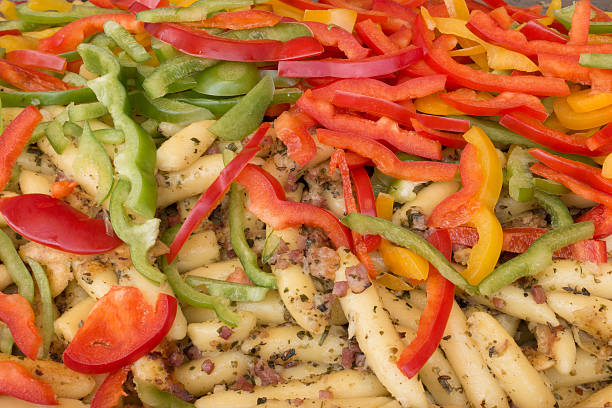 Close-up of Mohnnudeln and colourful red and green bell pepper slices