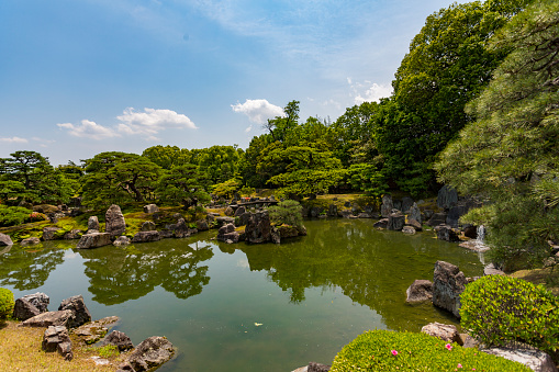 Kyoto, Japan - May 20, 2015: Ninomaru Garden, a traditional Japanese landscape garden with a large pond, ornamental stones and manicured pine trees in the grounds of Nijo Castle in Kyoto Japan