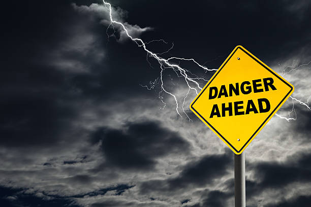istock Danger Ahead Sign Against Cloudy and Thunderous Sky 517157554