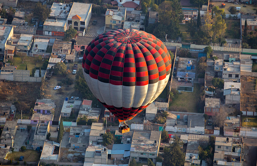 A morning ride on hot air balloons over a residential area of Mexico City.  The weather was perfect and the sunrise was beautiful.  The helium gave us the power to get above the other balloons.