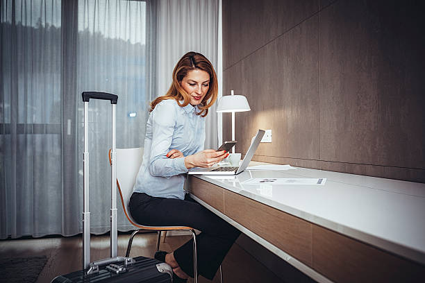 Young businesswoman using mobile  phone  in hotel room stock photo