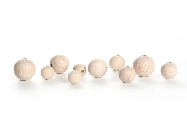 four big six small wooden beads, speheres on white background