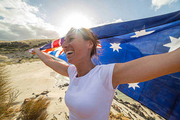 istock Cheering woman on beach holding Australian's flag 517164112