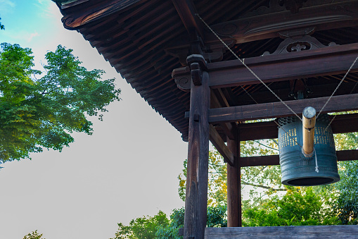 Cast iron door bell in front of a house entrance with a beautiful garden blurred  in the background on a summer day