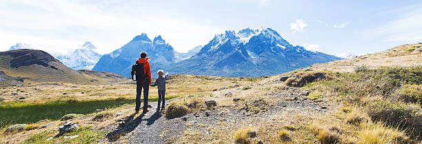 family hiking in patagonia panorama view of family enjoying active vacation in patagonia and hiking in torres del paine national park, chile cuernos del paine stock pictures, royalty-free photos & images