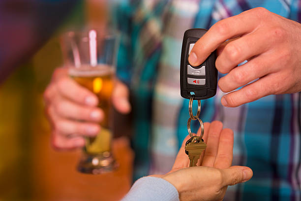 Drinking and Driving.  Man gives car keys to friend.  Beer. stock photo