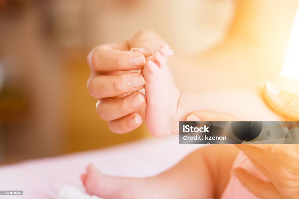 Baby with mother, she is holding her feet Adult Stock Photo