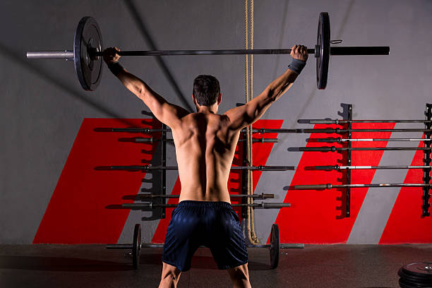 barre d'haltères homme vue arrière salle de sport - barre dhaltères photos et images de collection