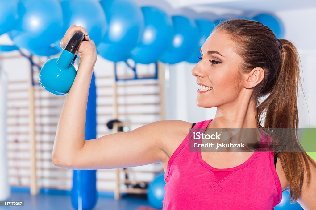 Portrait of a young pretty woman holding weights (dumbbell) and Portrait of a young pretty woman holding weights (dumbbell) and doing fitness indor. gym hall. Gym shot Active Lifestyle Stock Photo