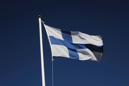 Flag of Finland on dark blue sky.