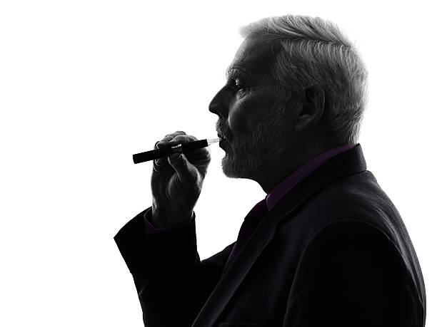 istock senior business man smoking electronic e-cigarette silhouette 517172269