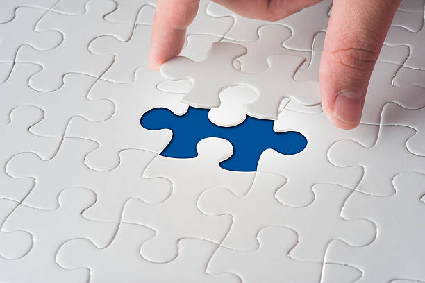 istock Hand holding the last piece of jigsaw puzzle 517172525