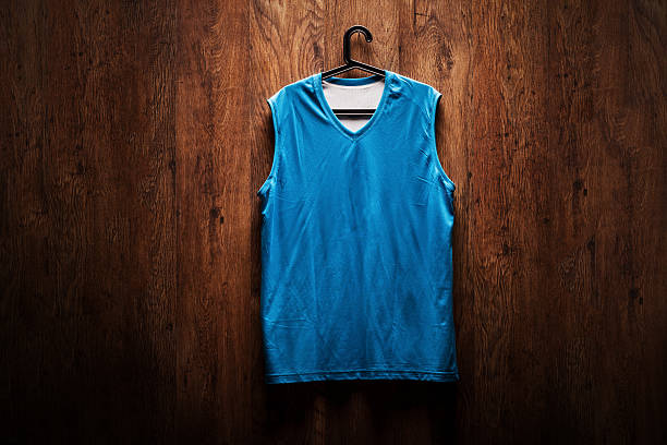 blu maglia da basket appeso su una parete di legno - shirt hanger hanging blue foto e immagini stock