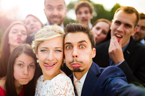 istock Newlyweds with friends taking selfie 517173175