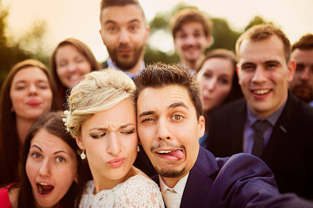 istock Newlyweds with friends taking selfie 517173181