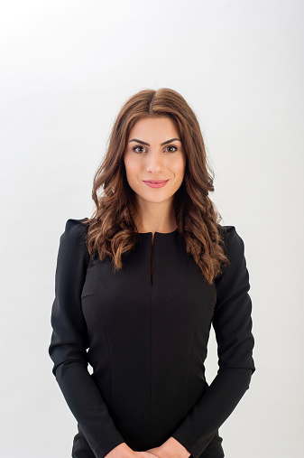 Portrait of a confident young business woman wearing black elegant dress and looking at camera!