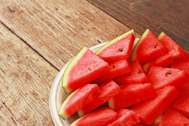 istock Sliced watermelon on white plate and wooden background 517180064