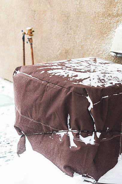 istock Residential air conditioning unit wrapped with protective cover in blizzard 517182502