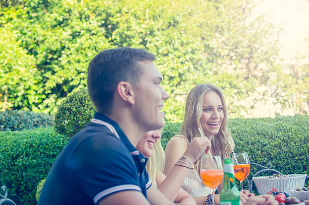 Group of young people eating outdoors.