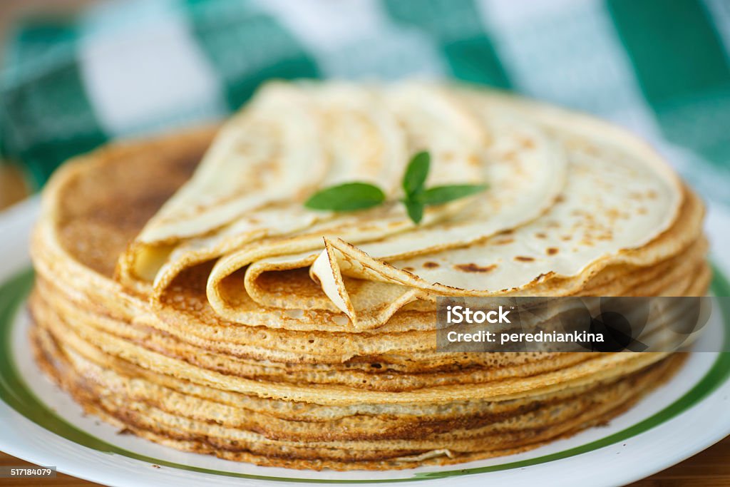 many thin pancakes many thin pancakes on a plate on a wooden table Backgrounds Stock Photo