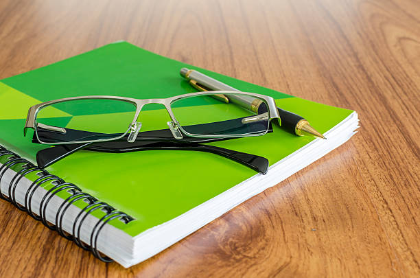 istock Green diary  with glassess gold pen on wood table 517184335
