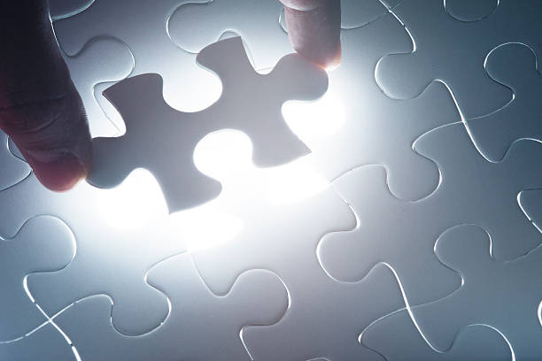istock Hand holding the last piece of jigsaw puzzle 517185457