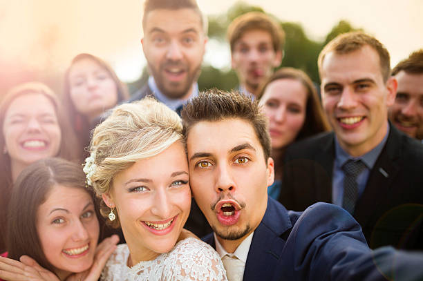istock Newlyweds with friends taking selfie 517186529