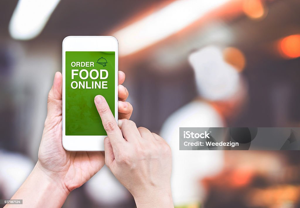 Hand halten Handy und Speisen bestellen Online mit Weichzeichnen Restaurant - Lizenzfrei Bestellen Stock-Foto
