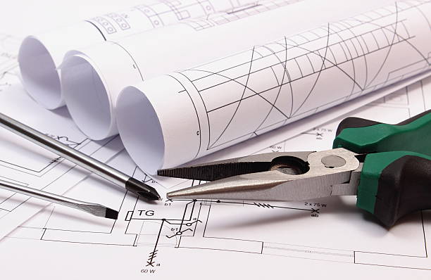 istock Rolls of diagrams and work tools on electrical construction drawing 517187296