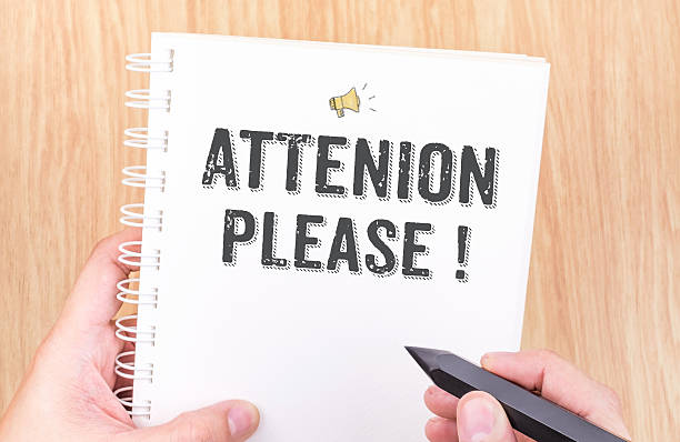 istock Attention please! word on white ring binder notebook with hand 517187386