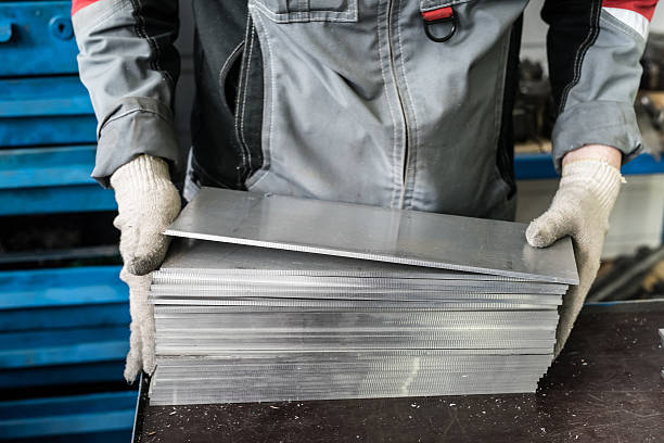 small stack of steel plates on the bench miller small stack of steel plates on the bench miller, hand in working glovessmall stack of steel plates on the bench miller, hand in working gloves sheet metal stock pictures, royalty-free photos & images
