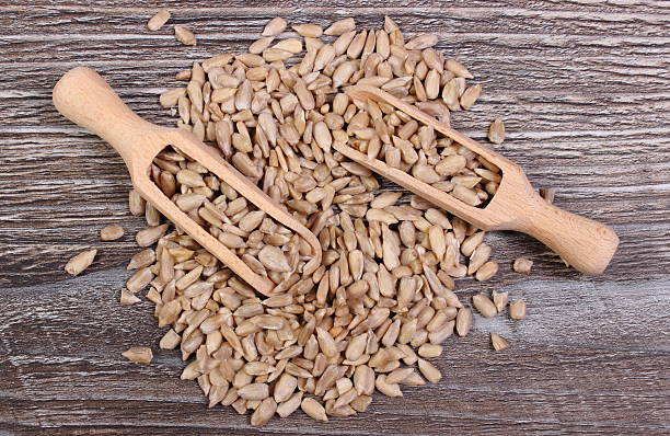 istock Sunflower seeds with spoon on wooden background 517187790