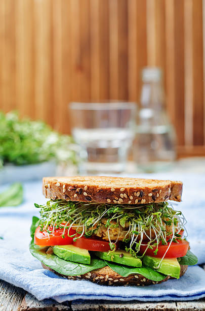 istock sprouts avocado tomato spinach chickpeas burger rye sandwich 517191392