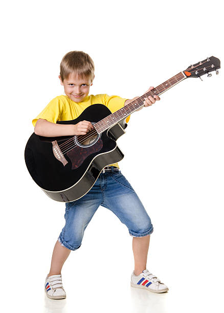 istock boy stands and plays guitar 517192996
