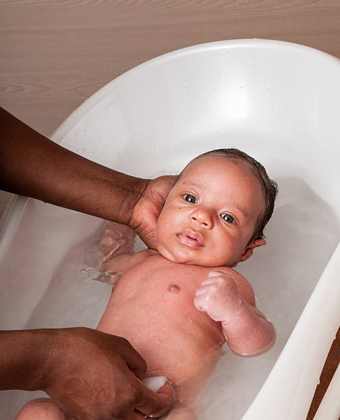 крупным планом из a две расы детские имея a ванной - baby1 стоковые фото и изображения